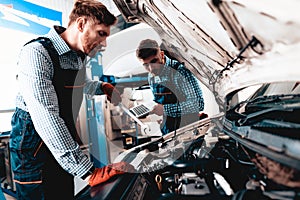 Young Auto Mechanic Repairs Car With A Wrench.