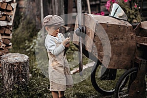 A young aviator boy near a homemade airplane in a natural landscape to fix a propeller with a wrench . Gives the picture