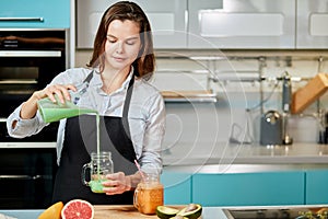 Young awesome woman pouring cocktail herself