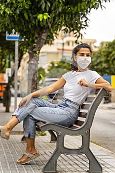 Young Azerbaijani Girl Wears White Face Mask, Sits on Bench in Street