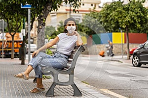 Young Azerbaijani Girl Wears White Face Mask, Sits on Bench in Street