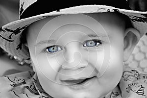 The A young baby is in black and white with bright blue eyes. Use it for a child or parenthood concept.