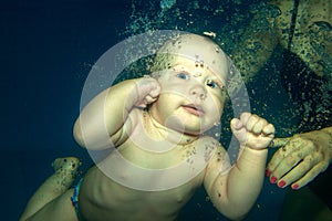 Young baby diving in the swimming pool