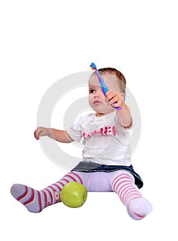 Young baby girl brushing teeth and fresh green apple