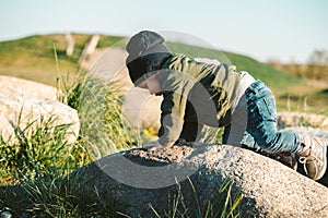 Young baby girl climbing on rock