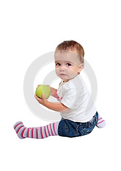 Young baby girl eating fresh green apple