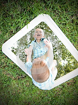 Young baby looking at self in mirror while smiling