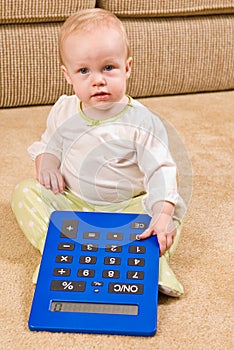 Young baby in PJs with a large over-sized calculat