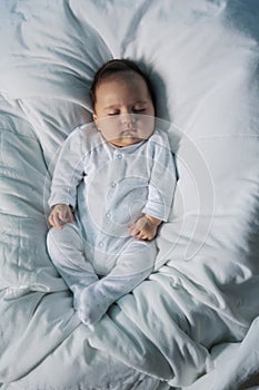 A young baby sleeping peacefully in a couch, white background