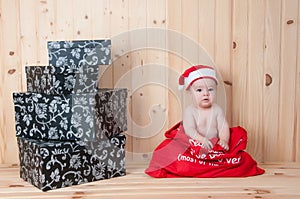 Young baby wearing a santa claus suit and hat in christmas in a barn