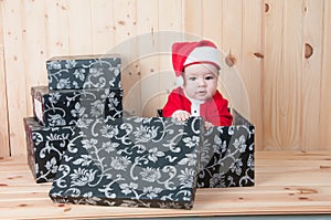 Young baby wearing a santa claus suit and hat in christmas in a barn