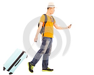 Young backpacker carrying a baggage and holding a smartphone