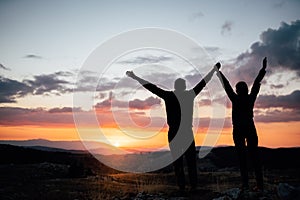 Young backpacker hiker couple enjoying relaxing mountain hike at sunset.Active hiking camping trip vacation in nature.Climbing up