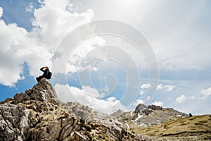 Young backpacker hiker man enjoying adrenaline mountain hike.Active hiking trip vacation.Climbing to the top of mountain cliff.