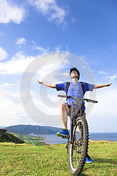 Young backpacker sitting on a mountain bike and relaxing pose