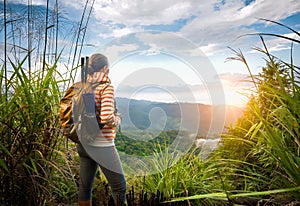 Young backpacker traveling along green mountains on sunrise