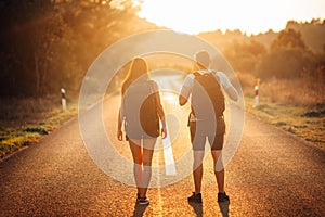 Young backpacking adventurous couple hitchhiking on the road.Adventure of life.Travel lifestyle.Low budget traveling.Adventurous