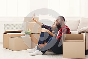 Young balck couple unpacking moving boxes