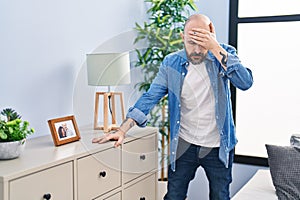 Young bald man suffering dizzy standing at home