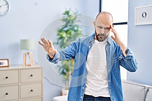 Young bald man suffering dizzy standing at home