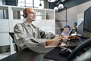 Young bald man working in a call center office