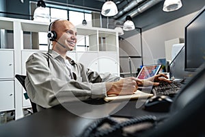 Young bald man working in a call center office