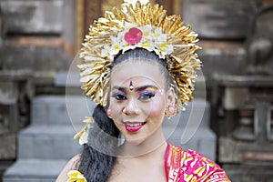 Young balinese dancer smiling in the temple