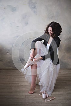 Young ballerina or dancer girl putting on her ballet shoes