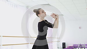 Young ballerina makes beautiful movements with her hands.