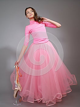 Young ballerina in a pink dress shows modern dance