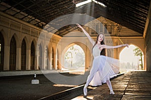 Young ballerina stands in a graceful pose on pointes