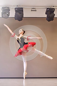 A young ballerina stands gracefully in pointe shoes on her toes in the studio.Ballet student practicing classical dance in studio