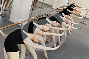 Young ballerinas doing exercises in studio.