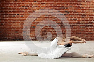 Young ballet dancer bending her back while performing splits