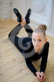 Young ballet dancer lying near the wall