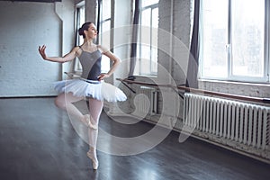 Young ballet dancer practice movement looking out the window in studio active lifestyle