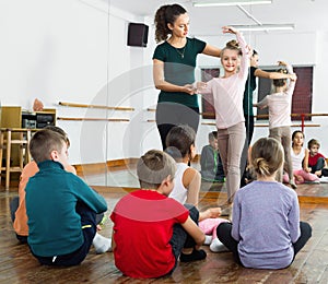 Young ballet dancers exercising in ballroom