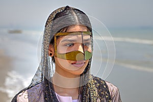 Young bandari woman wearing a traditional mask called the burqa.