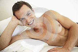 Young Bare Chested Man Relaxing On Bed