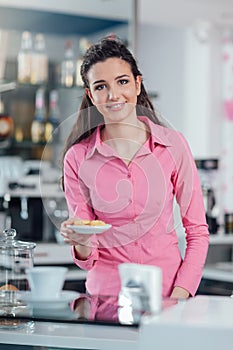 Young barista serving cookies