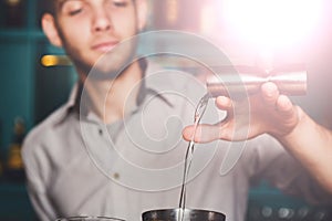 Young Barmans making shot cocktail, pouring alcohol into glass