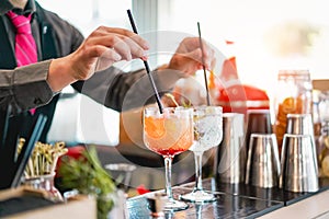 Young bartender making cocktails at bar counter - Barman serving drinks