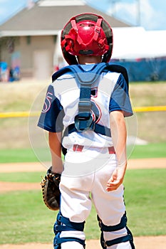 Young baseball catcher during game.