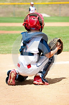 Young baseball catcher during game.