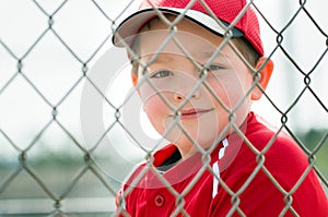 Young baseball player sitting in dugout