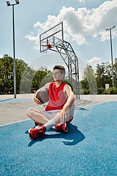 A young basketball player sits on
