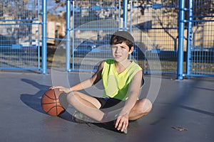 Young basketball player sitting on the court