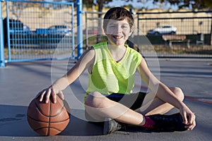 Young basketball player sitting on the court