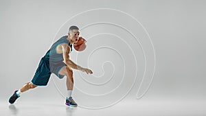 Young basketball player training isolated on white studio background