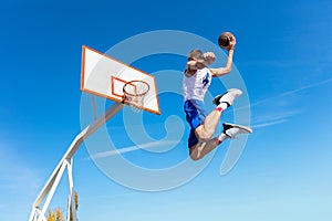 Young Basketball street player making slam dunk photo